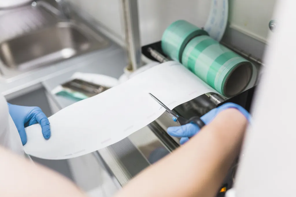 nurse-cutting-plastic-from-pouch-sealer-packaging-machinery.jpg